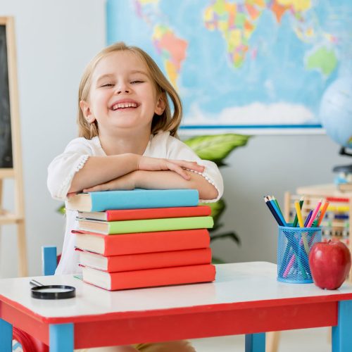 little-smiling-blond-girl-sitting-white-desk-holding-hands-books-spacious-school-class (2) little-smiling-blond-girl-sitting-white-desk-holding-hands-books-spacious-school-class (2)